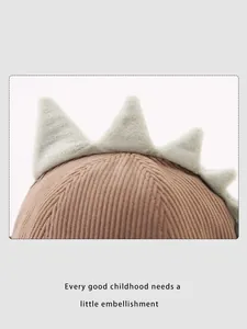 Détail du chapeau enfant en velours côtelé marron avec crêtes de dinosaure en peluche
