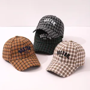Detail of four plaid baseball caps with Boston embroidery in wool blend texture