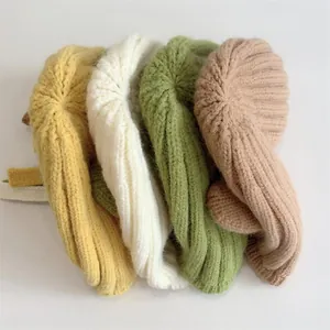 Nahaufnahme dicker Strickmützen für Babys mit Rippenmuster in vier verschiedenen Farben