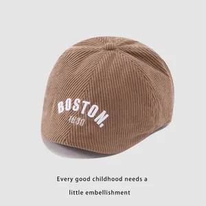 Detalle de gorra de pana marrón para niños con bordado BOSTON blanco y textura