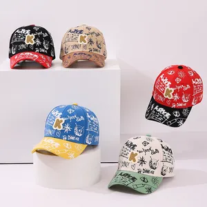 Detail showing five different color combinations of graffiti print baseball caps for kids