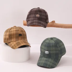 Detailed view of plaid wool baseball caps with 'm' embroidery in three autumn colors