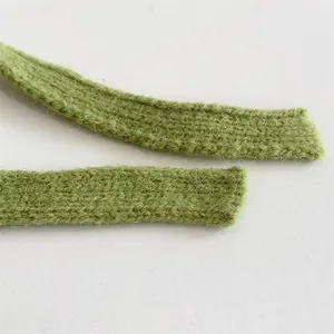 Nahaufnahme der grasgrünen Strickkordel mit weicher Textur und feinen Wollmischfasern