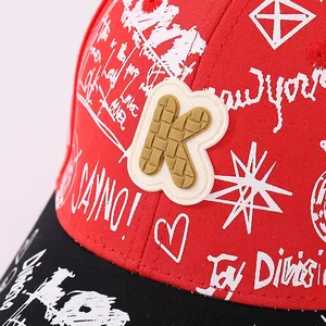Close-up of red and black kids baseball cap with 3D K patch and white graffiti text