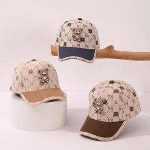 Dettaglio di cappellini da baseball in velluto a coste per bambini con orsetti in 3D