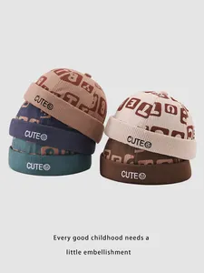 Macro shot of assorted corduroy Miki hats for kids with CUTE embroidery and ribbed texture