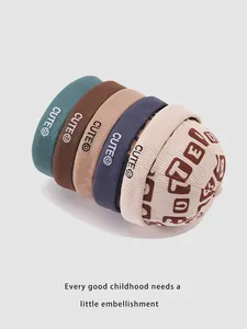 Close-up of winter corduroy beanies for kids with CUTE embroidery in five different colors