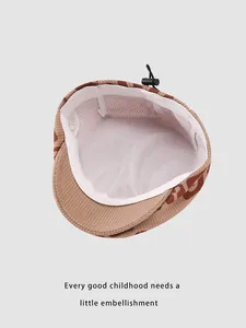 Detail of baby corduroy beret featuring breathable mesh lining and adjustable strap buckle