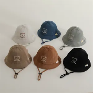 Flat lay of colorful waffle knit kids bucket hats with lucky bear embroidery and chin straps