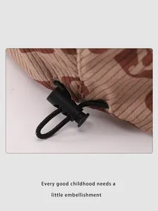 Detail of adjustable drawstring cord on a textured corduroy beret for children