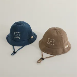 Detail of navy and khaki children's bucket hats with Lucky bear embroidery