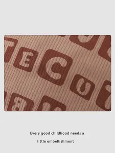 Macro shot of brown corduroy fabric texture with letter print on a stylish kid's hat