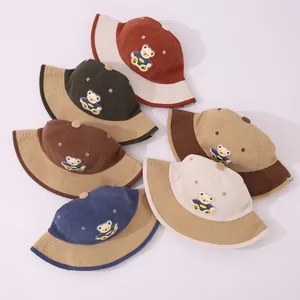 Stack of colorful corduroy kids bucket hats with bear embroidery patches for autumn