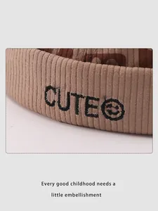 Close-up of CUTE embroidery and smiley face on ribbed beige corduroy kids hat