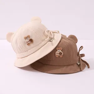 Detail of corduroy baby bucket hats with cute bear ears and Smile patch in beige and brown