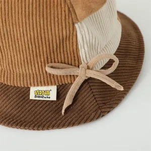 Detail of color block corduroy bucket hat with bow accent and fine fabric texture