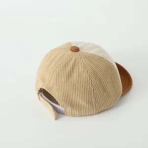 Detail view of the tricolor corduroy texture and adjustable velcro strap on the baby cap