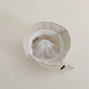 Detail view of the beige kids' bucket hat showing the soft lining and windproof drawstring