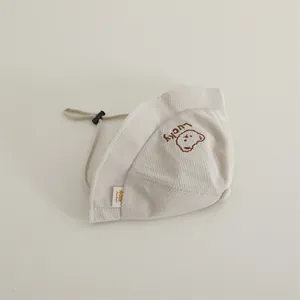 Close-up of Lucky bear embroidery and waffle texture on beige toddler sun hat