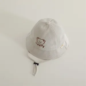 Detail of baby bucket hat with waffle texture, LUCKY bear embroidery and windproof cord