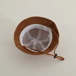 Detail of brown panda bucket hat interior with white lining and adjustable wind rope