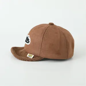 Side view of brown suede baby baseball cap with soft corduroy brim and letter M patch