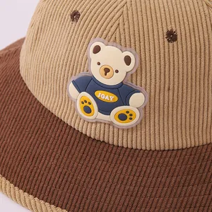 Close-up of corduroy material and cartoon bear patch on khaki toddler bucket hat