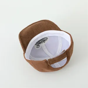 Detail view of brown corduroy baby hat with soft inner lining and adjustable strap