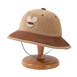Kids corduroy bucket hat with cartoon patch and brown color block design on stand