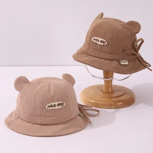 Detail of corduroy baby bucket hat with cute bear ears and nice day patch texture