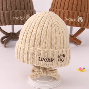 Drie kleuren gebreide babymutsen met Lucky-borduurwerk en winddichte vetersluiting