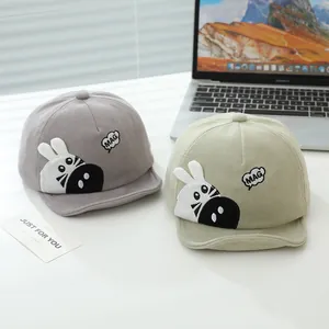 Detail of baby corduroy baseball caps featuring zebra embroidery and soft flip-brims