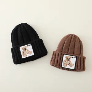 Warm thick knit beanie hats for kids featuring a cute teddy bear patch in black and brown