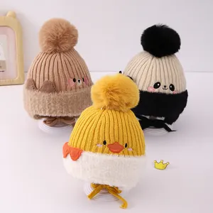 Detail der Baby-Strickmützen mit Bommeln und niedlichen Tierfiguren für den Winter