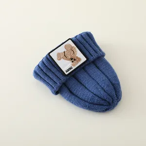 Detail of navy blue ribbed knit winter hat featuring a cute Teddy patch and woven texture