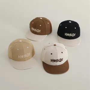 Dettaglio di cappellini da baseball per bambini color-block con ricamo Hello e smile