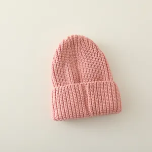 Vista macro del gorro de punto rosa para bebé con textura acanalada y detalle de doblez