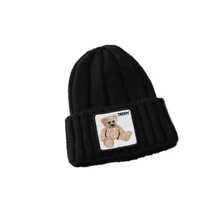 Thick black knitted beanie for kids with a cute teddy bear embroidery patch