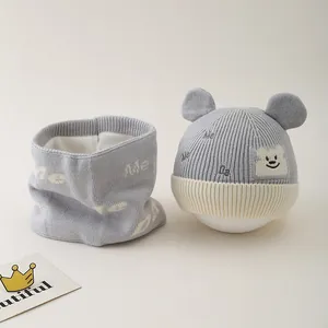 Detail of baby winter knit hat and scarf set showing thick warm fleece lining and bear patch