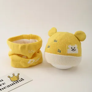 Close-up of baby winter knit hat and scarf set with soft fleece lining and bear patch