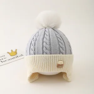 Detail of warm knit kids hat with fuzzy pompom and soft thick fleece lining texture