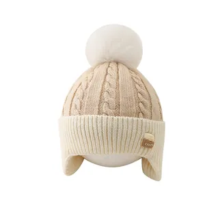 Thick knitted winter earflap hat for kids aged 2-6 with a large pom pom and choco label