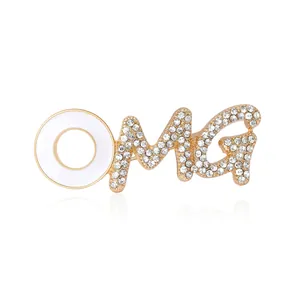 Vintage gold alloy OMG brooch with white enamel and sparkling rhinestones on white base