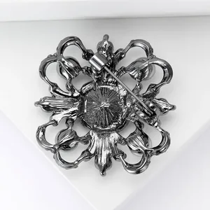 Detailed back view of vintage flower brooch showing safety pin clasp and textured metal