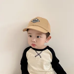 Detail of khaki baby baseball cap with mountain patch worn by child model