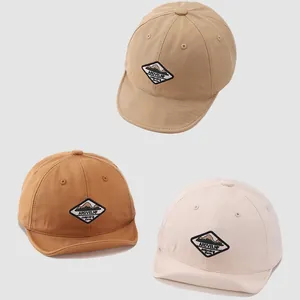 Three minimalist soft brim baby baseball caps in khaki, caramel, and cream cotton fabric