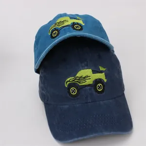 Detailed close-up of monster truck embroidery on blue cotton kids' baseball caps