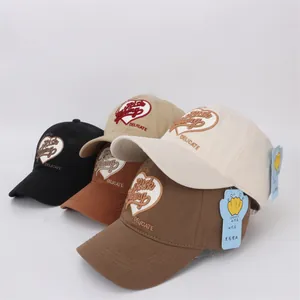 Vue détaillée de quatre casquettes de baseball en coton avec broderie de cœur soignée