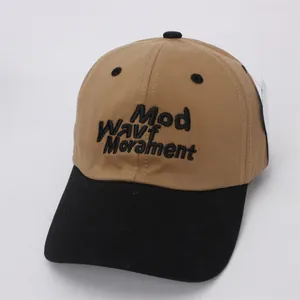 Detail of embroidered Mod Wavf lettering on khaki and black color-block baseball cap