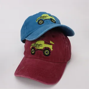 Detail of blue and burgundy kids baseball caps featuring monster truck embroidery